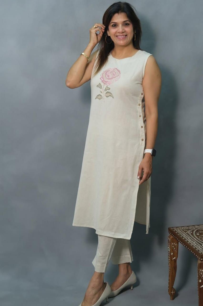 Off-White Sleeveless Cotton Kurti Set with Hand-Embroidered Floral Motif.