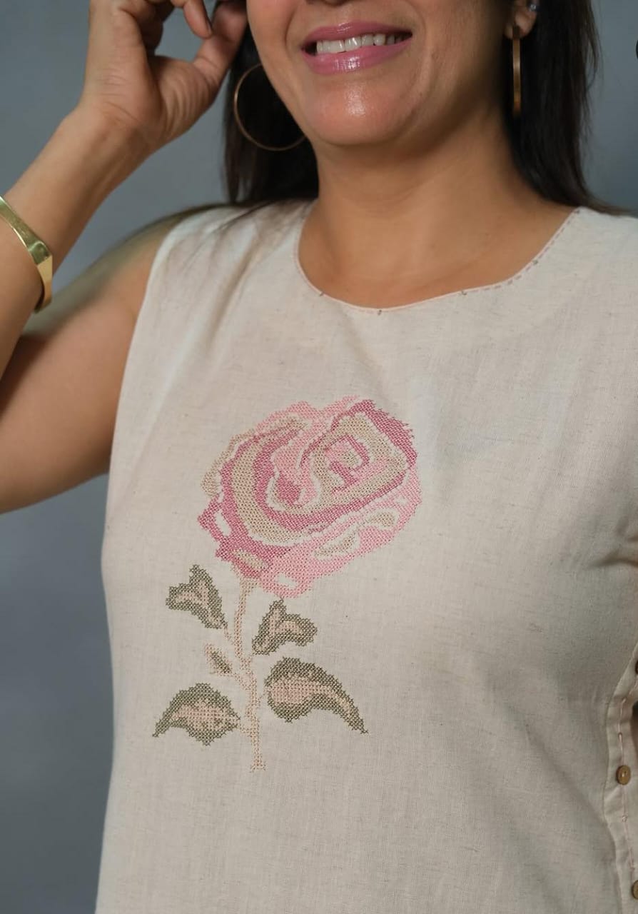 Off-White Sleeveless Cotton Kurti Set with Hand-Embroidered Floral Motif.